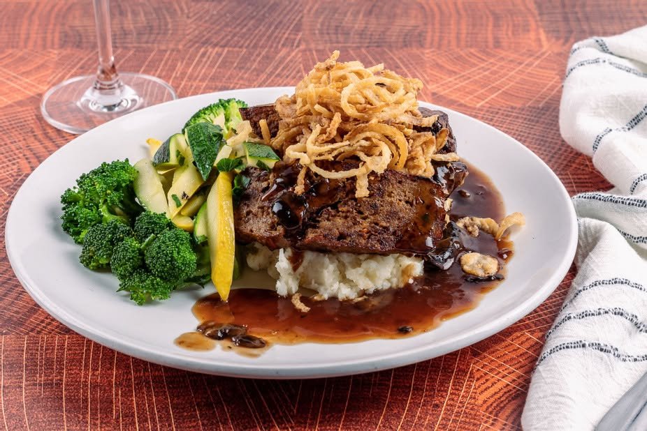 House meatloaf with crispy onions over mashed potatoes